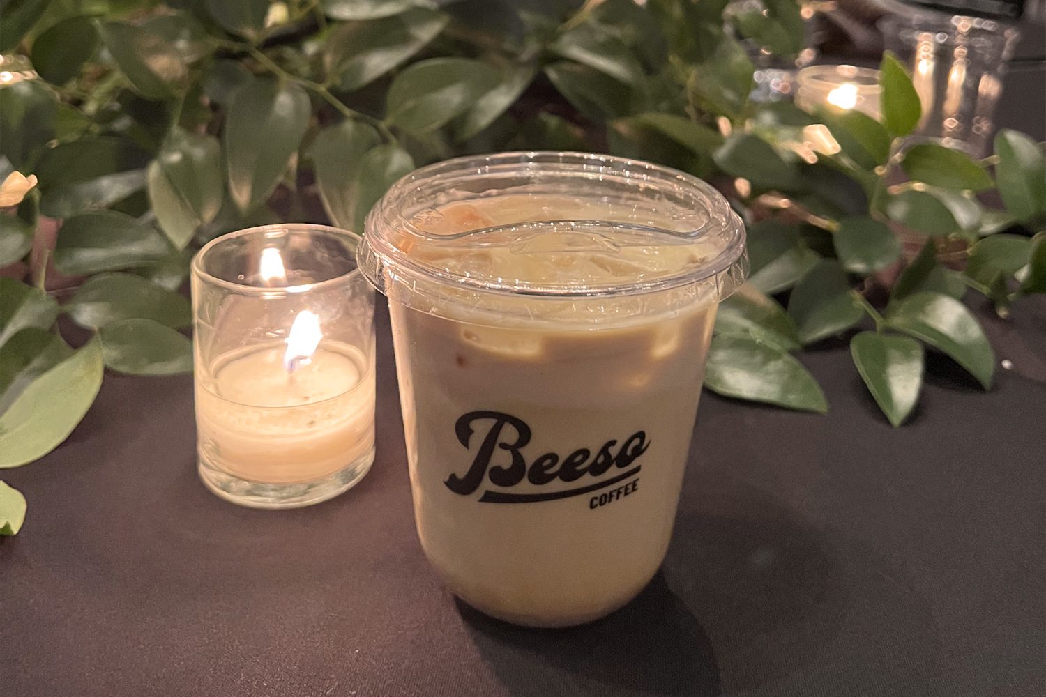 a candle and a beeso cup of coffee